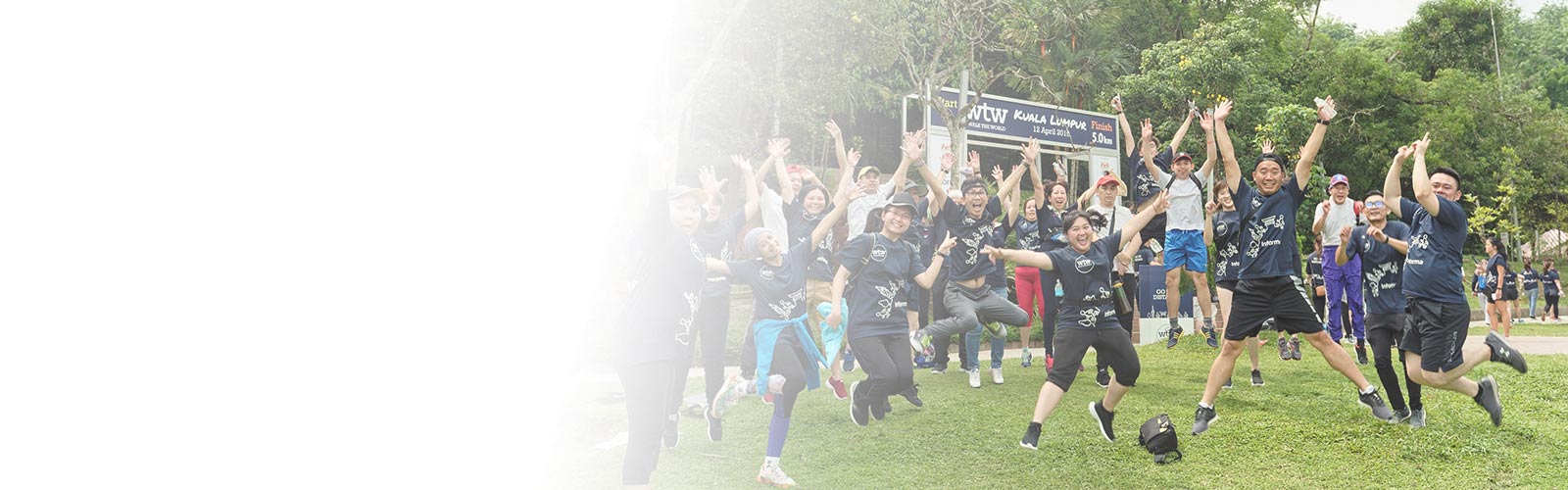 A group of people jumping in the air together wearing Walk the World t-shirts