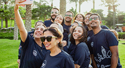 A photo of a group of Informa colleagues taking a selfi picture in their Walk the World t-shirts